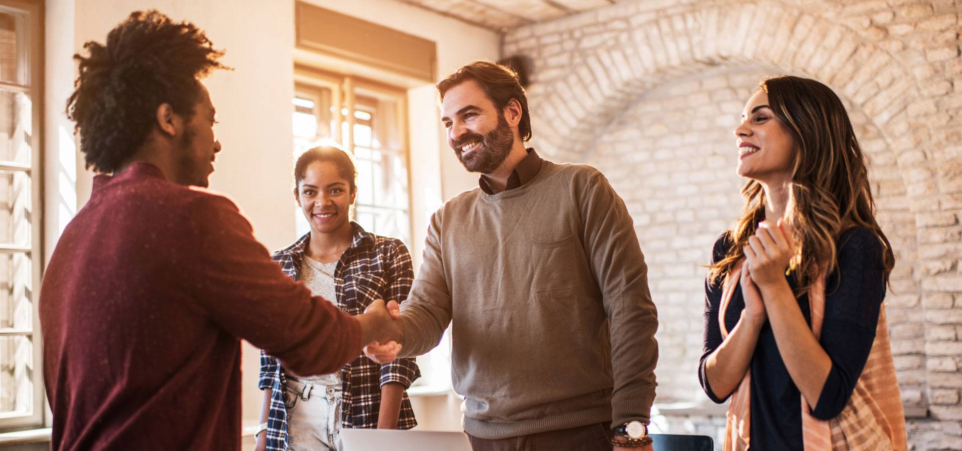 Business people received a new member into their team. Shaking hands.