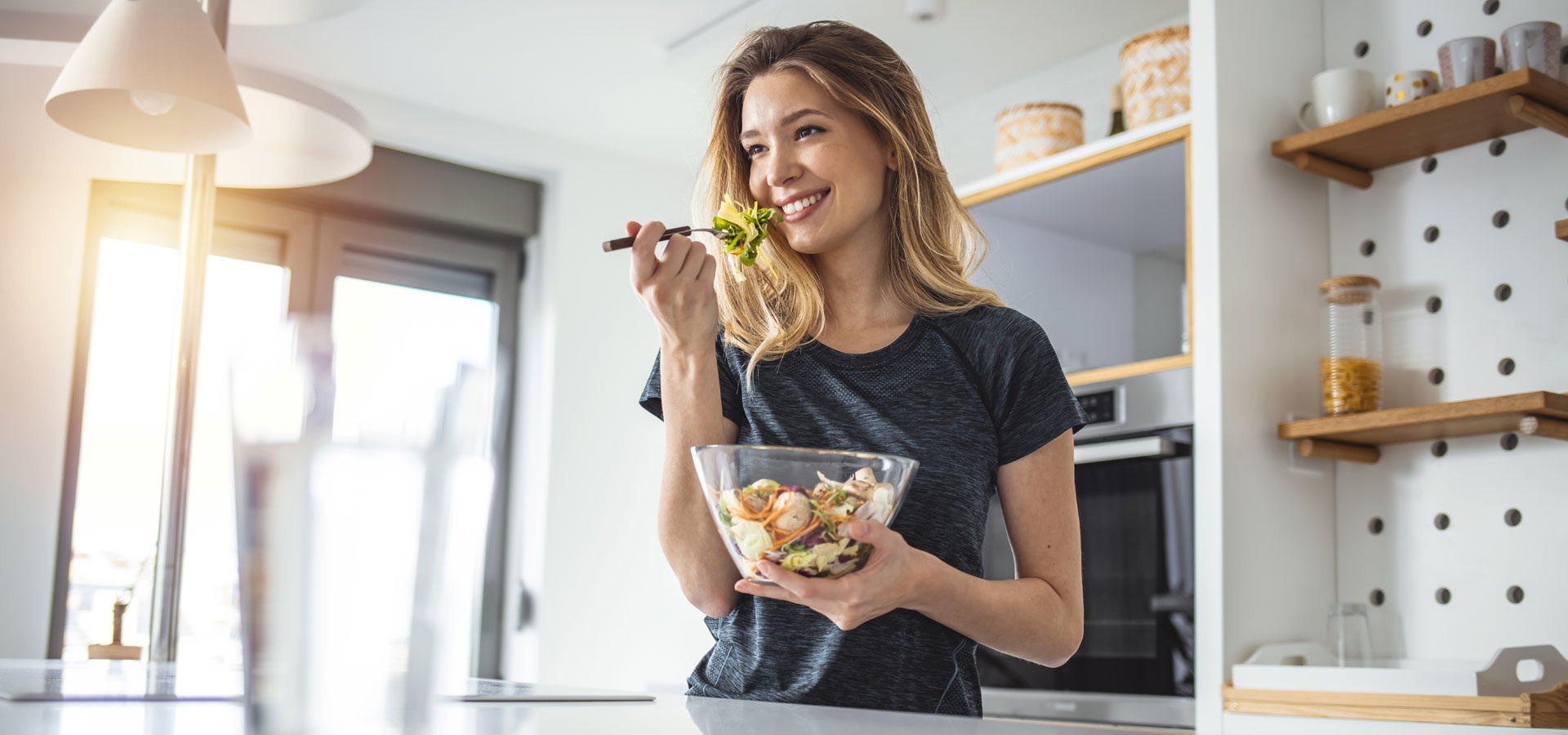 woman laughing eating salad