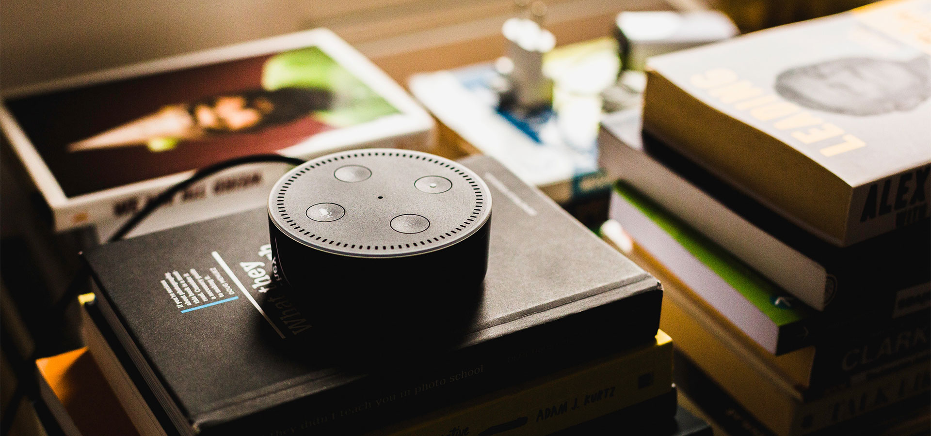 Amazon Echo Dot sitting on stack of books