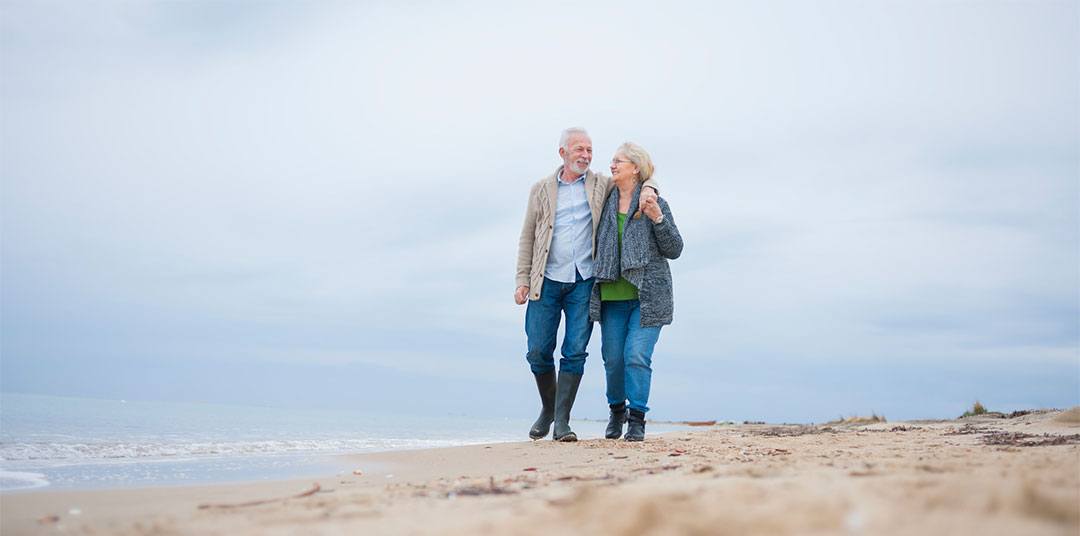 Elderly couple walking on the beach