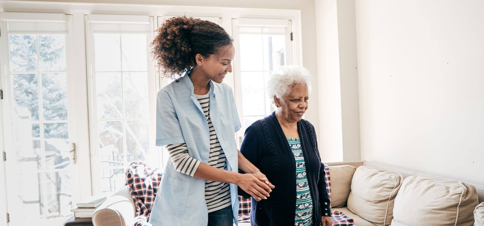 caregiver helping elderly woman