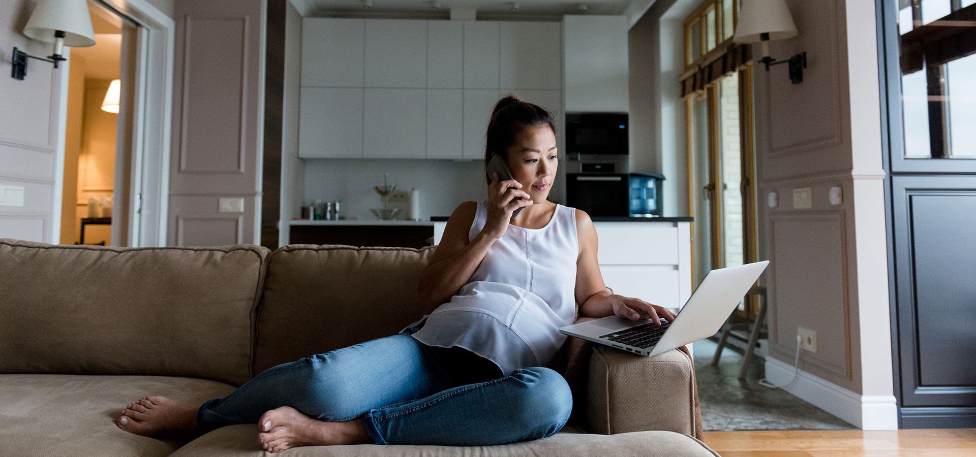 Pregnant woman uses laptop at home