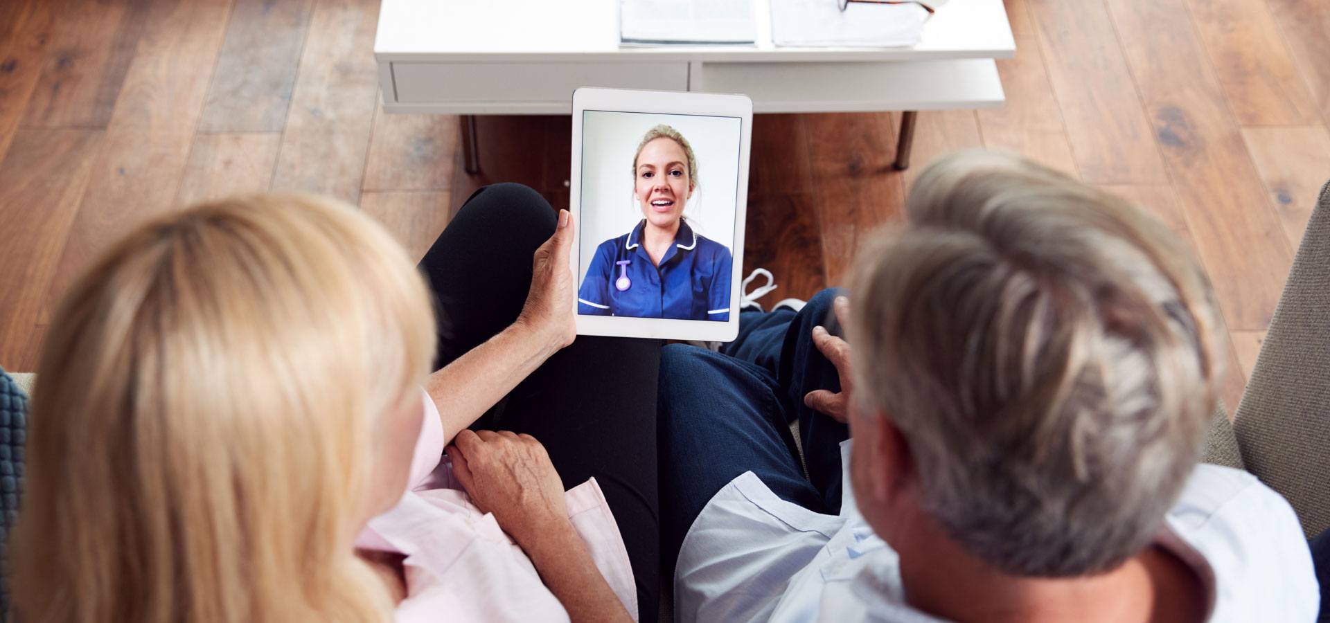 Mature Couple Having Online Consultation With Female Nurse At Home On Digital Tablet