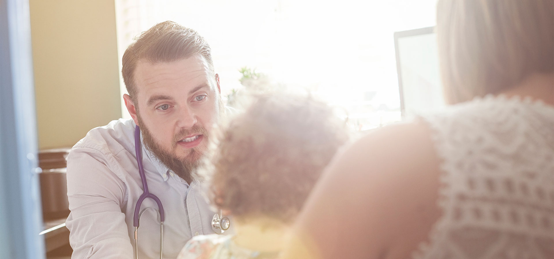 male doctor meeting with mom and child