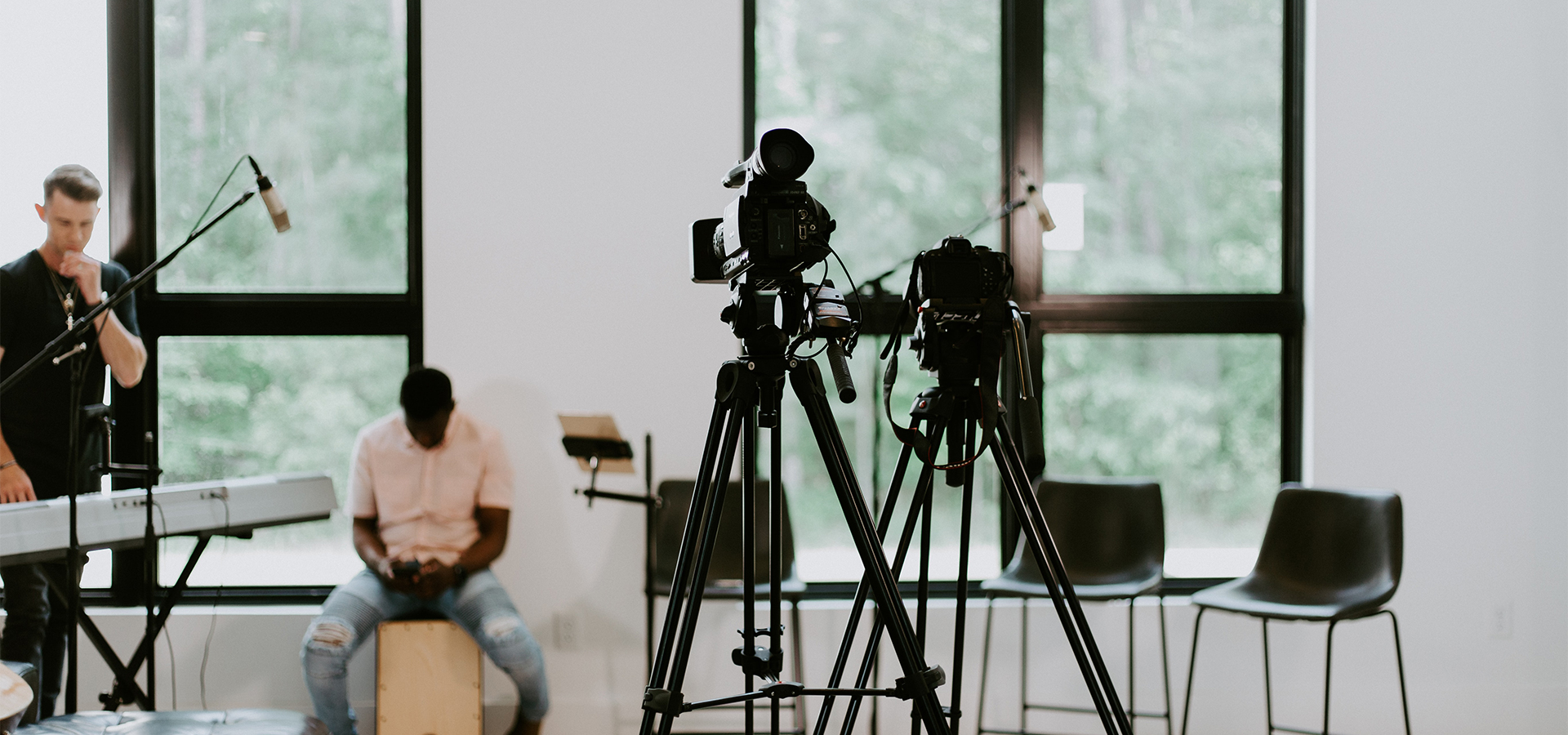 2 men sitting on chair in front of camera