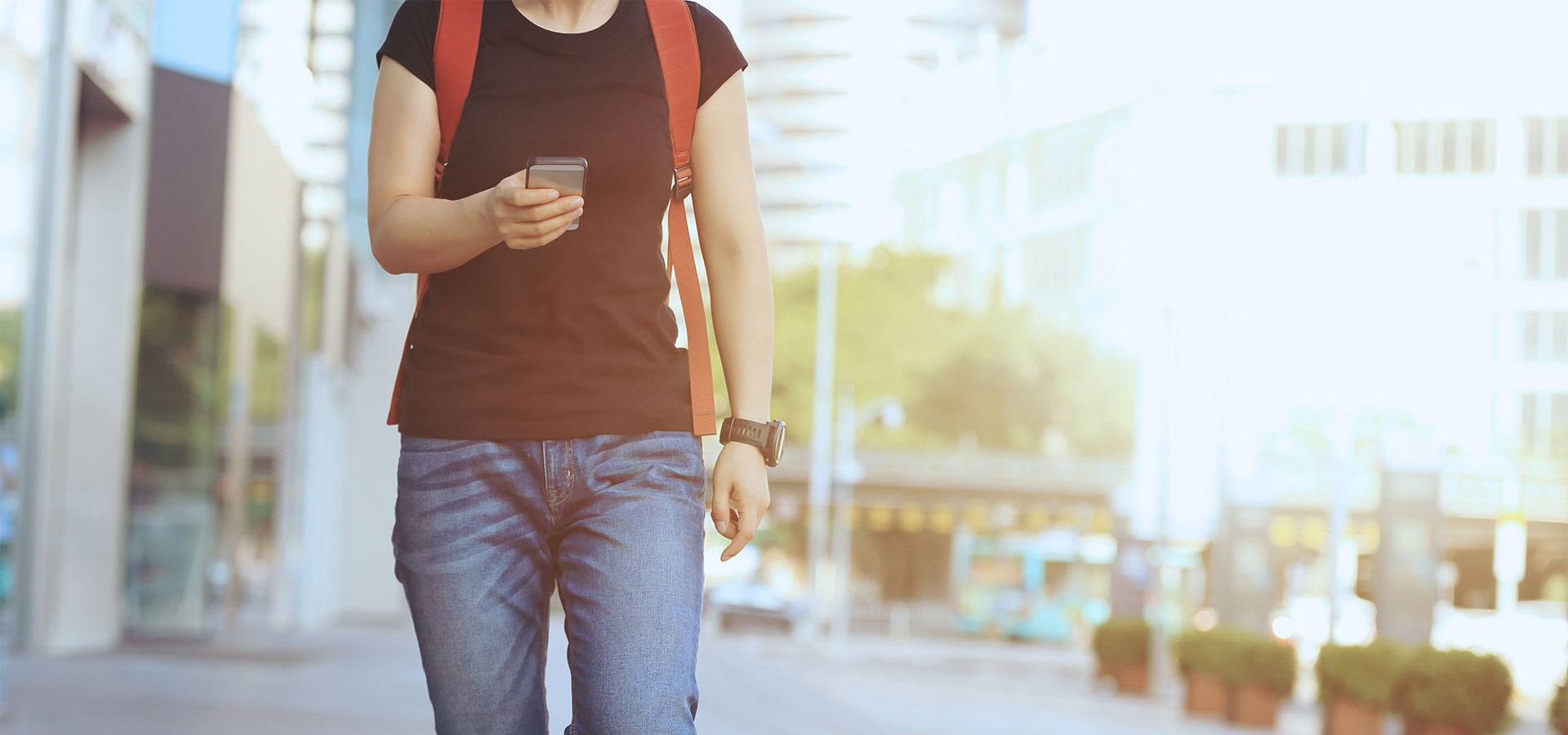 Person walking on sidewalk looking at phone