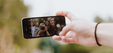 person holding space gray iPhone SE showing man holding camera photo